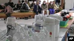 地震幸存者聚集在临时避难中心,这些中心的水、食物和燃料稀少