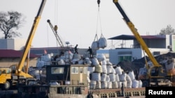 一只中国边境贸易的货船停泊在朝鲜新义州的岸边,正在卸货(资料照片)