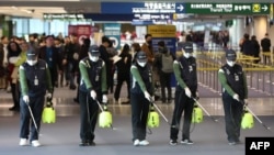 韩国仁川国际机场的工人为防范新型冠状病毒入侵在海关处喷洒消毒药水。(2020年1月21日)