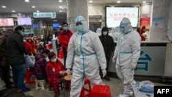 资料照:武汉红十字医院身穿防护服的医务人员和等候就诊的病患。(2020年1月25日)