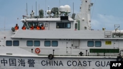 在南中国海有争议海域正在执行补给任务的菲律宾海岸警卫队看到了中国海警船上的人员。(2024年8月26日)