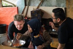 Seorang pedagang di pasar (tengah) meminjamkan dapur dan kompornya kepada Gordon Ramsay agar ia bisa memasak rendang (dok: National Geographic/Ed Wray)
