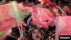 在台北民进党总部外的蔡英文总统的支持者举旗欢呼。(2020年1月11日)