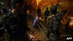 Binh sỹ Thái Lan đưa dây cáp điện vào hang Tham Luang ở công viên Khun Nam Nang Non của tỉnh Chiang Rai hôm 26/6 trong chiến dịch tìm kiếm đội bóng U-16 mất tích cùng huấn luyện viên của họ.
