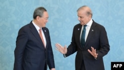 资料照片: 2024年10月16日,巴基斯坦总理谢赫巴兹·谢里夫(右)在伊斯兰堡举行的上海合作组织(SCO)峰会期间与中国总理李强交谈。