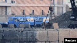 Những chiếc xe tải đỗ cạnh một đống than bên bờ sống Áp Lục, biên giới giữa Trung Quốc và Bắc Triều Tiên.