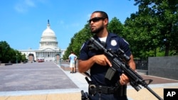 在美国联邦众议院多数党党鞭斯考利斯在维吉尼亚州亚历山大市棒球场遭枪手开枪打伤后，一位国会警察在国会大厦附近站岗（2017年6月14日）