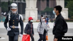 资料照片--游客在经过台北中正纪念馆的升旗仪式时,戴上防护口罩以保护自己免受冠状病毒病(冠状病毒)的侵袭。(2020年3月11日)