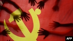 中国江苏连云港的一所小学校的学生在上中共党史课时把手放在中共党旗上。(2020年6月28日)