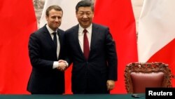 法国总统马克龙与中国国家主席习近平在北京举行联合记者会后握手。(2017年1月9日)