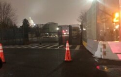 资料照片:夜幕降临被高高的围栏所远远环绕的国会山。(2021年2月15日)