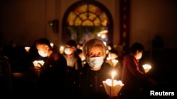 资料照片:新冠疫情期间,人们在上海的一座天主教堂参加复活节守夜礼。(2021年4月3日)