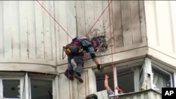 视频截图显示调查人员正在查看莫斯科一栋被乌克兰无人机袭击的建筑。(2023年5月30日)