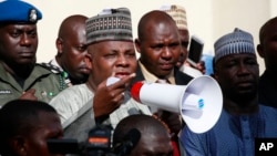 Thống đốc bang Borno, ông Kashim Shettima, giữa, nói chuyện với những người biểu tình kêu gọi chính phủ giải cứu những nữ sinh bị bắt cóc ở trường trung học Chibok, Abuja, Nigeria.