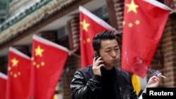 在北京,有人拿着香烟走过一家餐厅(2015年)