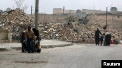 People carry their belongings as they flee Kadi Askar area towards the Bustan al-Qasr neighbourhood, in rebel-held besieged Kadi Askar area of Aleppo, Syria, Dec. 5, 2016.