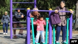 资料照：北京天坛公园里的老年人和他们的独生子女的孙辈在锻炼身体。（2011年10月25日）