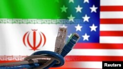 Kabel LAN terlihat di depan bendera AS dan Iran dalam ilustrasi yang diambil pada 23 April 2024. (Foto: Dado Ruvic/Reuters)