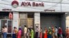 People wait for a branch of the AYA Bank to open, ahead of a long holiday stretch for the Myanmar New Year, also known as Thingyan, in Yangon on April 12, 2021, as the country remains in turmoil after the February military coup. (Photo by STR / AFP)