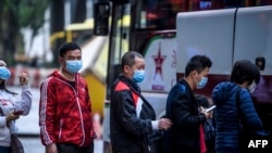 澳门新东方置地酒店外戴口罩的游客在排队登上游览车。(2020年1月22日)