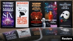 纽约曼哈顿百老汇剧院区的广告旁走过一名戴着口罩的男子。(2020年3月12日)