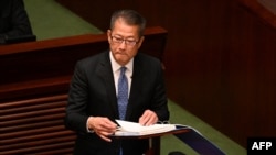 2月26日,香港财政司司长陈茂波在香港立法会会议厅发表年度预算演讲。 (画面来源:法新社)