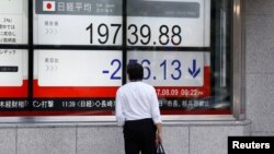 在东京商业区的一家证券行外面,有人看着日经指数(2017年8月9日)