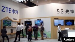 在巴塞罗那举办的移动世界会展中,人们路过中兴通讯的展台。(2018年2月26日)