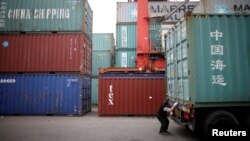 一名韩国司机在仁川港货运码头检查一个“中国海运”的集装箱。(2016年5月26日)