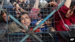 加沙地带贾巴里亚难民营的巴勒斯坦人正在等待领取免费食品。(2024年3月18日)