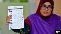 2023年9月9日马尔代夫总统选举在马累举行,一名选举工作人员在计票时展示选票