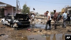 Cư dân vây quanh hiện trường một vụ đánh bom ở Karbala, ngày 29/4/2013. Một loạt các vụ tấn công đã giết chết nhiều người Iraq trong tháng 4, gây nên nỗi lo sợ là bạo động giáo phái vốn đã giết chết hàng chục ngàn người hồi năm 2006 và 2007 sẽ nổi lên trở lại.