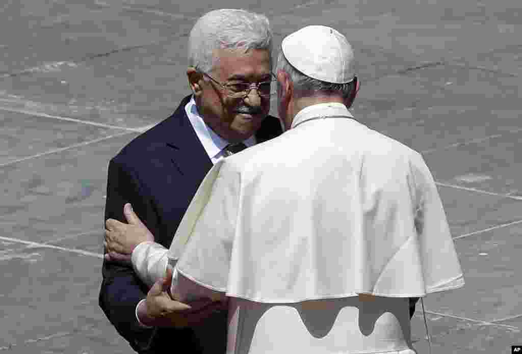 Pope Francis greets Palestinian President Mahmoud Abbas following a canonization ceremony in St. Peter's Square at the Vatican, May 17, 2015.