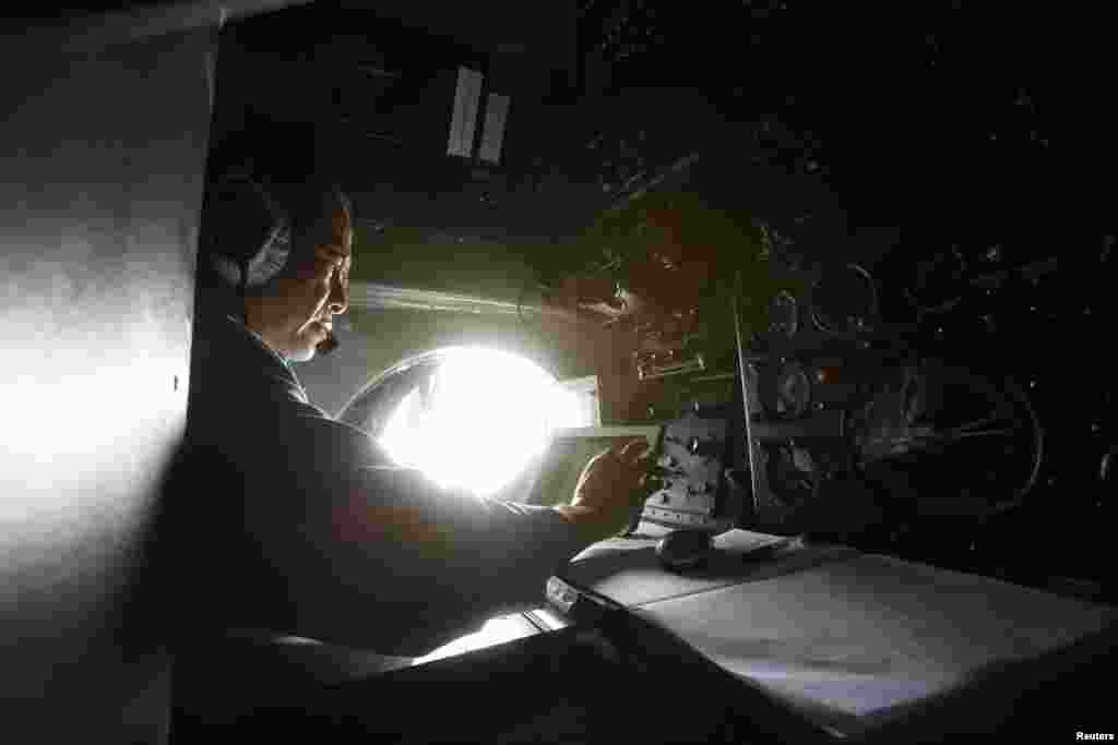 Sĩ quan quân đội Dương Văn Lành làm việc trên máy bay AN-26 của không quân Việt Nam trong một nhiệm vụ tìm kiếm người mất tích ngoài khơi đảo Thổ Chu, ngày 11 Tháng 3, 2014.