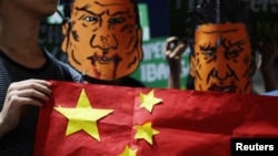 菲律宾学生头戴杜特尔特总统和中国国家主席习近平的漫画脸谱举行反华示威集会(路透社2018年11月20日)