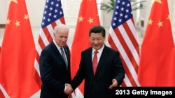 资料照：2013年12月4日中国国家主席习近平与来访的美国副总统拜登握手 