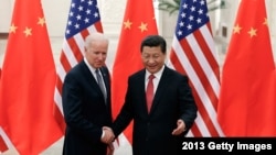 资料照片:,中国国家主席习近平在北京人民大会堂与当时的美国副总统乔·拜登握手合影。(2013年12月4日)