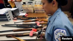 Viên cảnh sát Chicago đang kiểm kê súng thu được từ sự kiện "Đổi súng lấy thẻ quà tặng", theo đó mỗi cây súng được giao nộp lại cho cảnh sát ở Illinois, Chicago sẽ nhận được một thẻ quà tặng, ngày 28/5/2016.