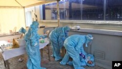 在新德里,几位医护人员在救助一位因长时间工作而晕倒的同事(2021年4月27日)。