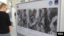 俄罗斯官媒塔斯社去年夏季在莫斯科举办介绍中俄友谊图片展览。一位行人在观看50年代有关中苏友谊的图片。(美国之音白桦拍摄)