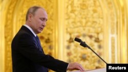 普京在莫斯科克里姆林宫举行的就职典礼上手按宪法第四次宣誓就任俄罗斯总统。(2018年5月7日)