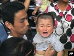 一名因食用毒奶粉而患病等候做超声波检查的儿童在哭泣(资料照片）