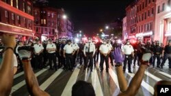 Protesters take a knee on Flatbush Avenue in front of New York City police officers during a solidarity rally for George Floyd, June 4, 2020, in the Brooklyn borough of New York.