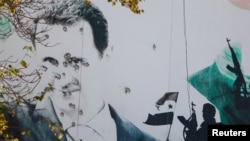 资料照:叙利亚总统巴沙尔·阿萨德被驱逐后,大马士革街头一块广告牌上的阿萨德头像上布满弹孔。(2024年12月16日)