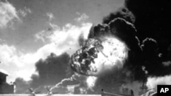 1941年12月7号,美国珍珠港遭到日本战机袭击,美国水手站在飞机残骸前(资料照)