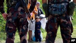 匈牙利士兵拦住一家希望从塞尔维亚进入匈牙利的移民或难民。 (2015年9月15日)