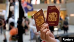 一名香港示威者在反对港版国安法的抗议中手举英国国民海外护照(BNO)。（2020年6月1日）