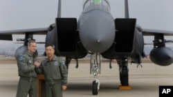 有关美国空军B-52轰炸机飞行任务的新闻发布会结束后,驻韩美军中将奥肖内西和韩国空军将领李莞根在一架韩国F-15战机前合影。