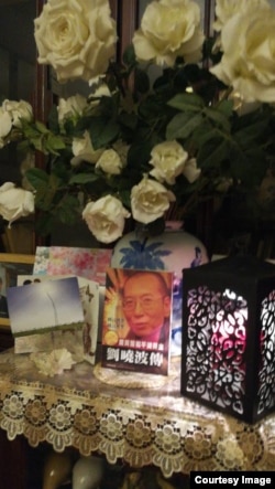 2017年7月19日凌晨,悼念者家中燃烛摆花祭奠刘晓波。(推特图片)