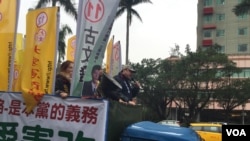 吾尔开希在竞选卡车上。他周四,即台湾选举日前夕,冒雨在台北街头做竞选宣传。(美国之音萧洵摄影)